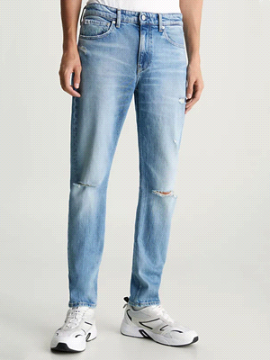 I jeans SLIM TAPER con rotture di CALVIN KLEIN JEANS fondono il comfort del denim elasticizzato con un look grintoso dato dalle rotture sulle ginocchia. A vita media, si adattano alla silhouette con u... 
