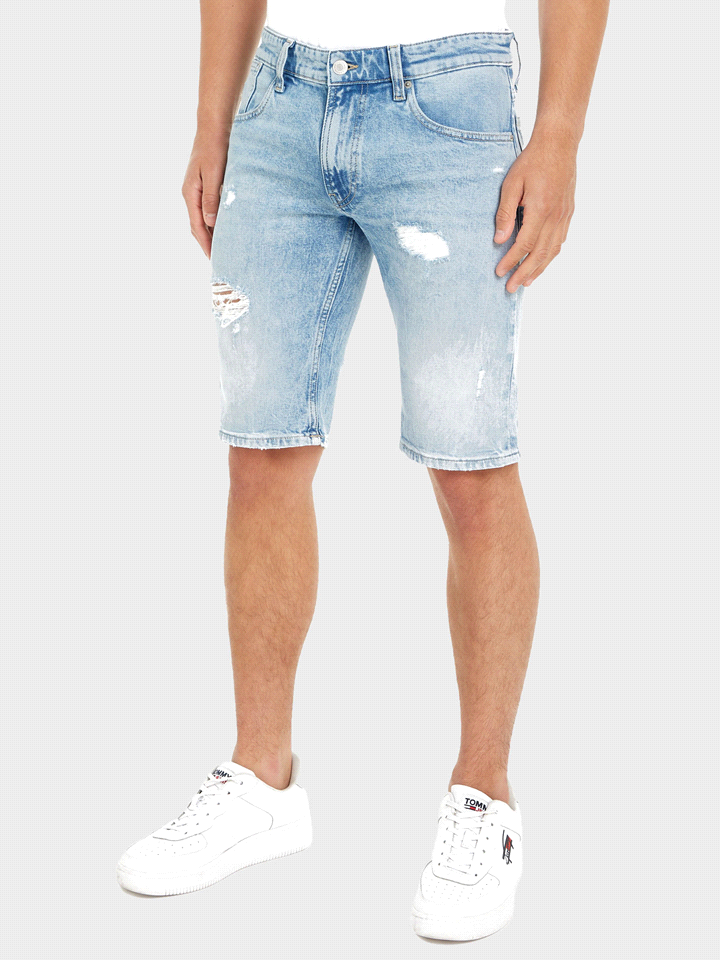 Il jeans TOMMY JEANS CORTO RONNIE, realizzato in denim di cotone elasticizzato, presenta una chiusura con cerniera e bottone, e un design cinque tasche classico per uno stile intramontabile e funziona... 